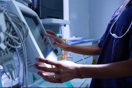 Woman working in hospital powered by a UPS for medical sector